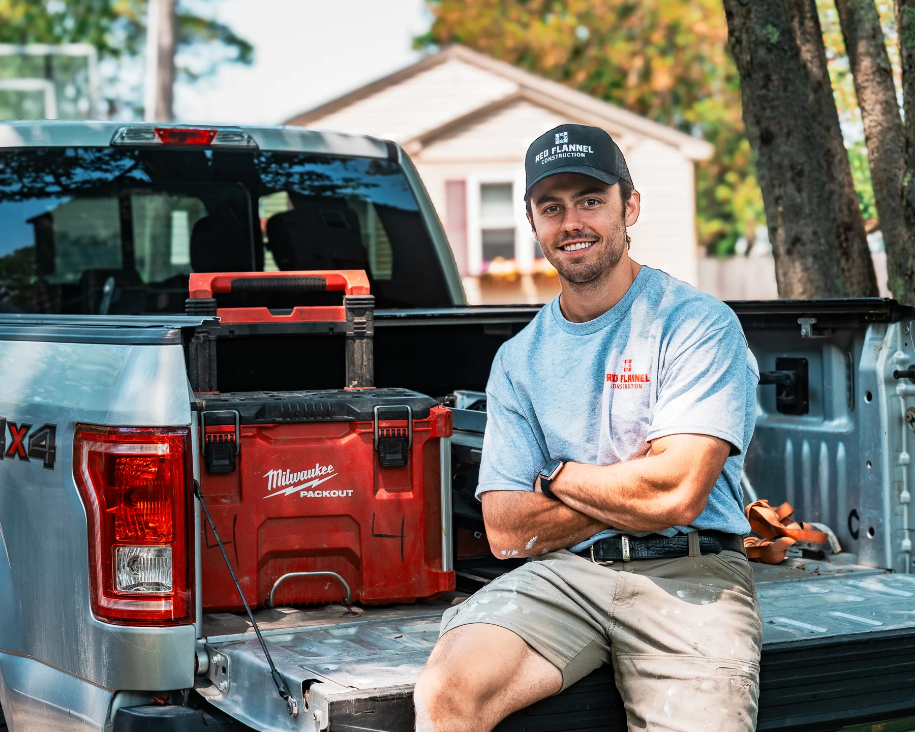 Red Flannel team portrait seated on a work truck